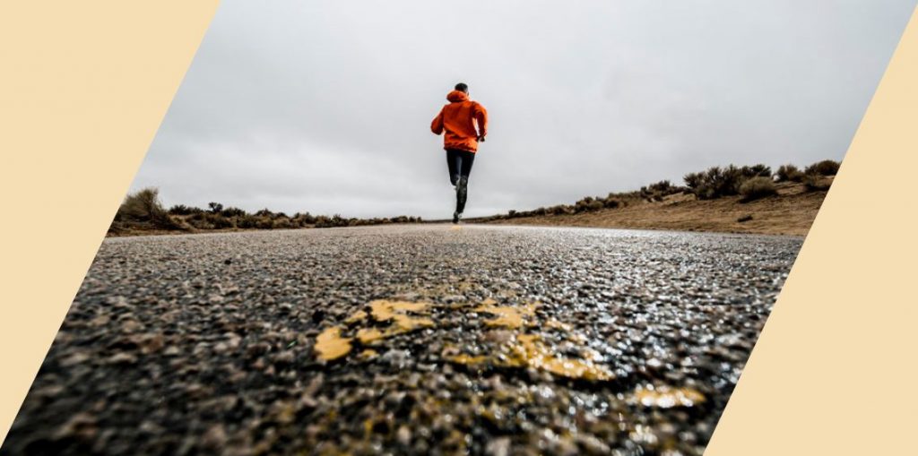 A person running on a paved surface into the distance
