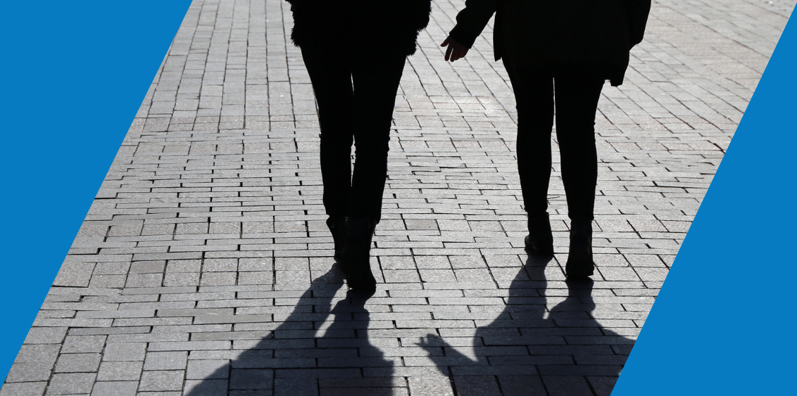 Silhouettes of two people walking and talking