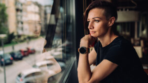 A woman in a black T-shirt sitting in a cafe by the window
